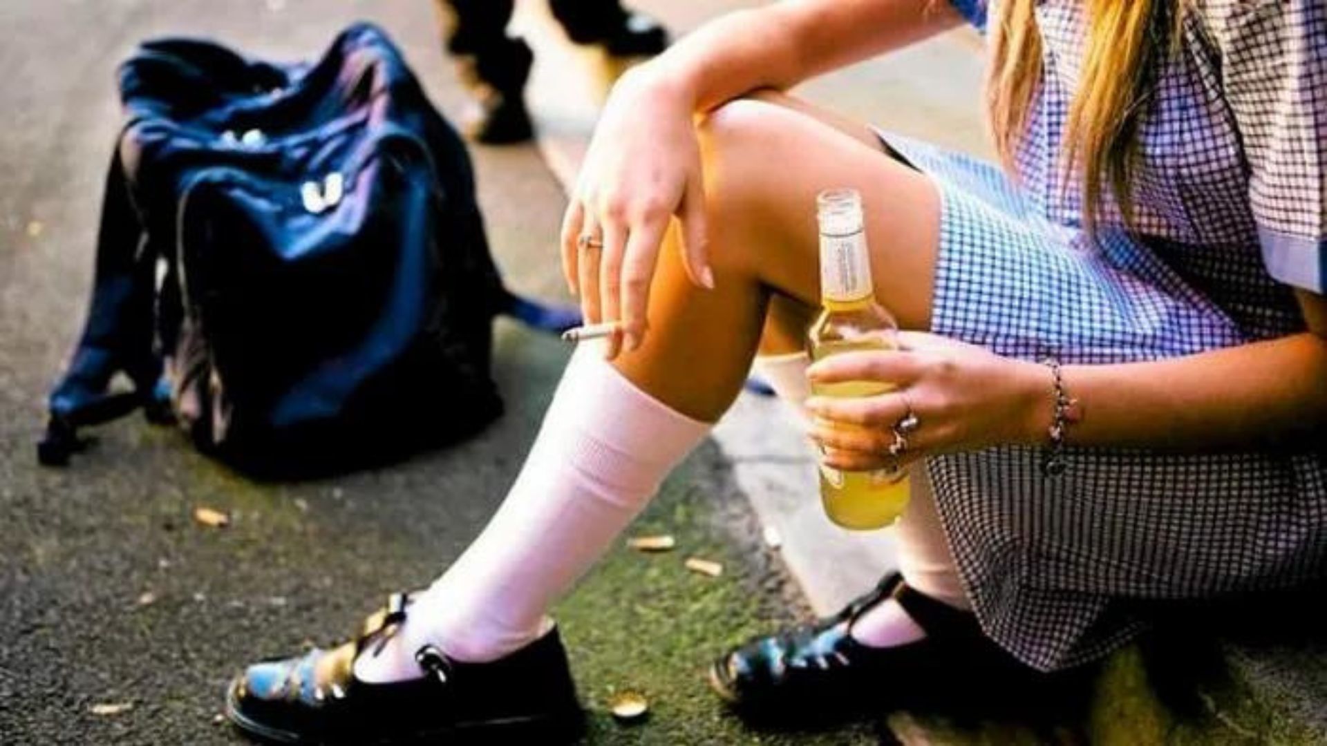a school teenage girl holding alcohol and a cigarette showing challenges facing youths 
