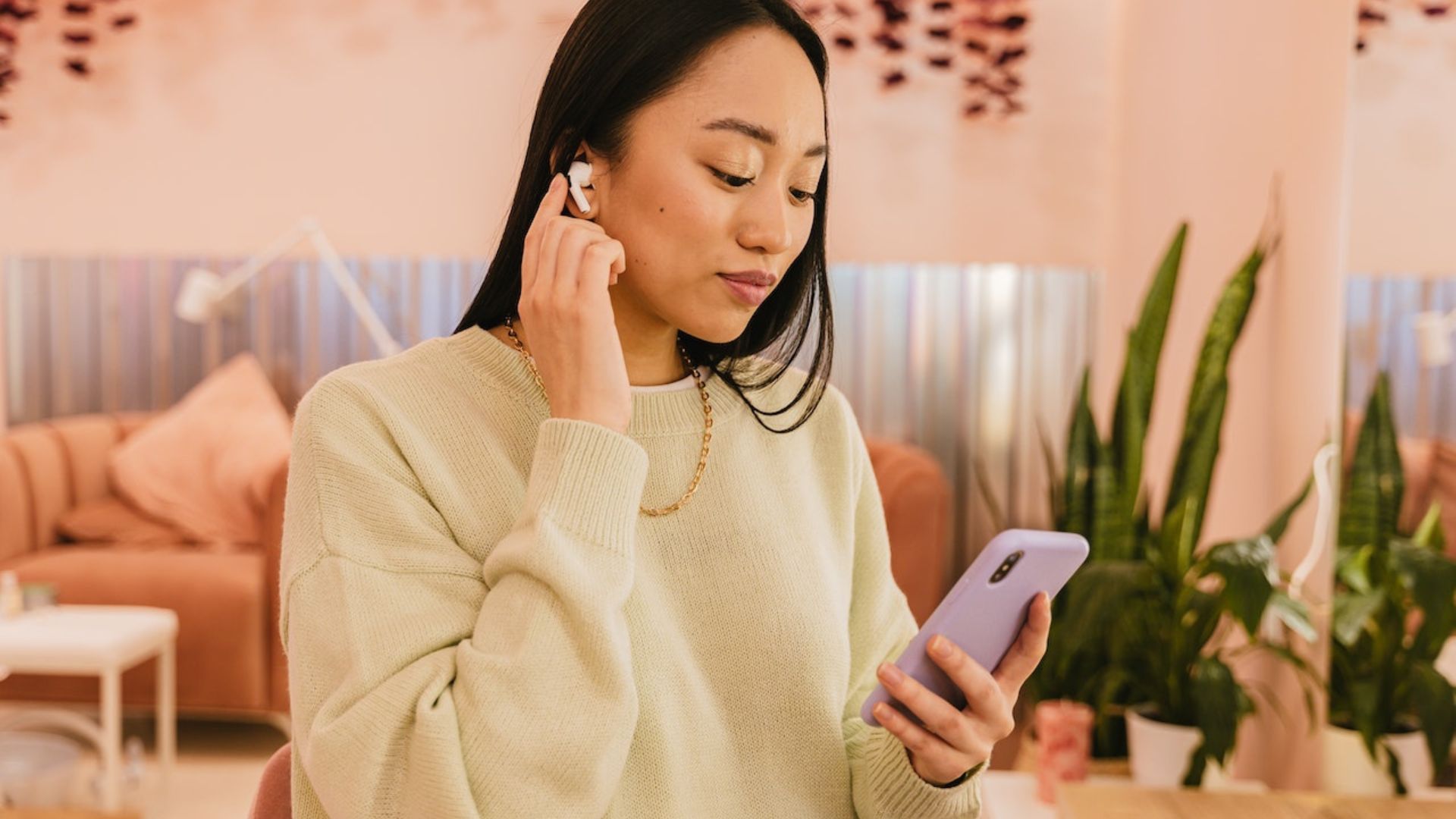 a young lady holding a phone with earphones showing the impact of social media on Youths' Mental Health